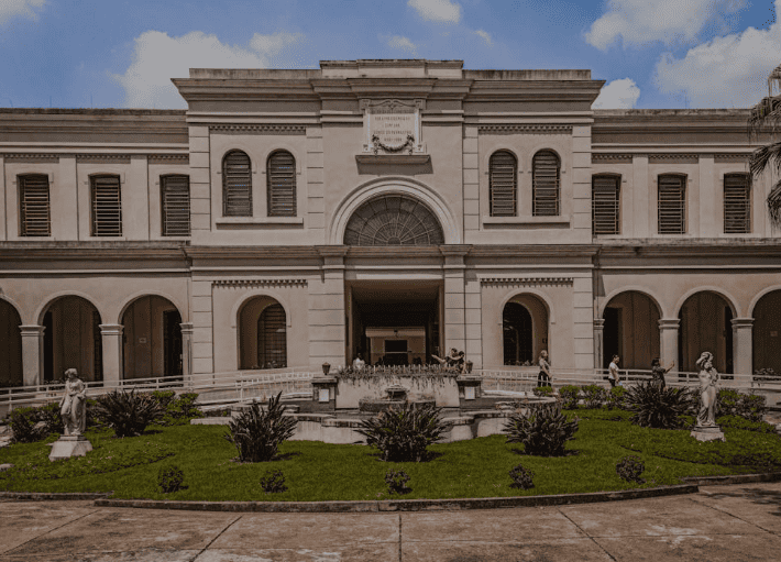 Entrada principal do Museu da Imigração em São Paulo com jardim e chafariz em primeiro plano.