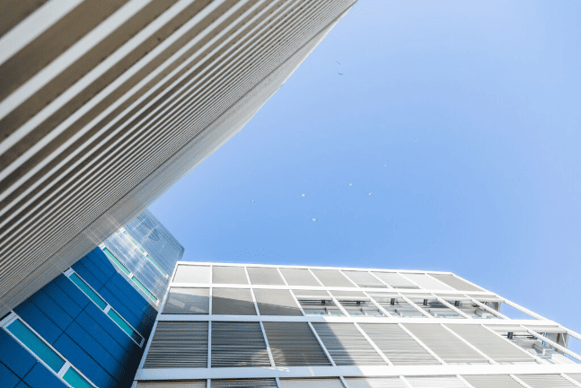 Fachada de um edifício comercial moderno com arquitetura geométrica sob o céu azul.