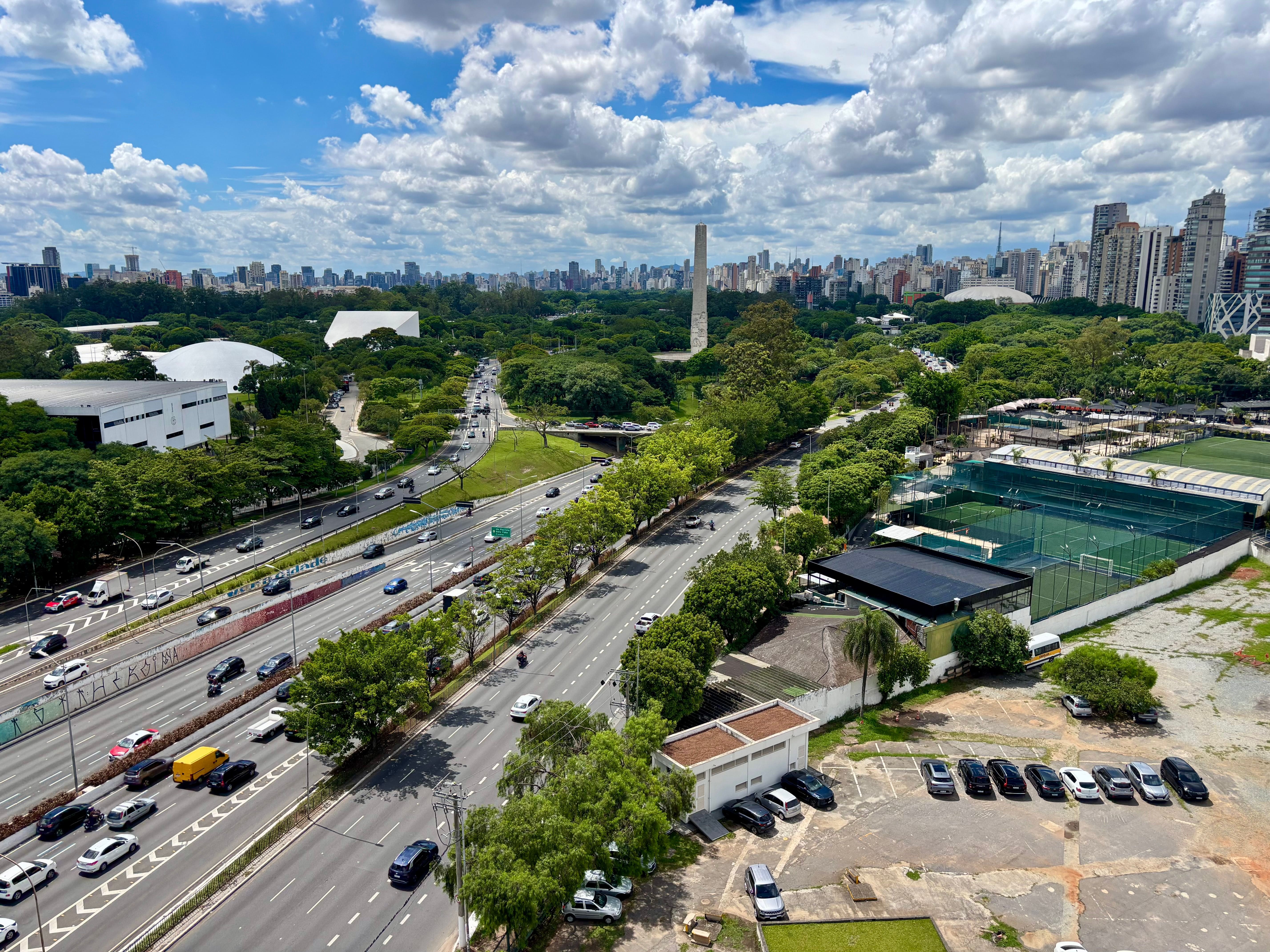 Vista aérea da Avenida 23 de Maio ao lado do Parque Ibirapuera com o Obelisco ao fundo.