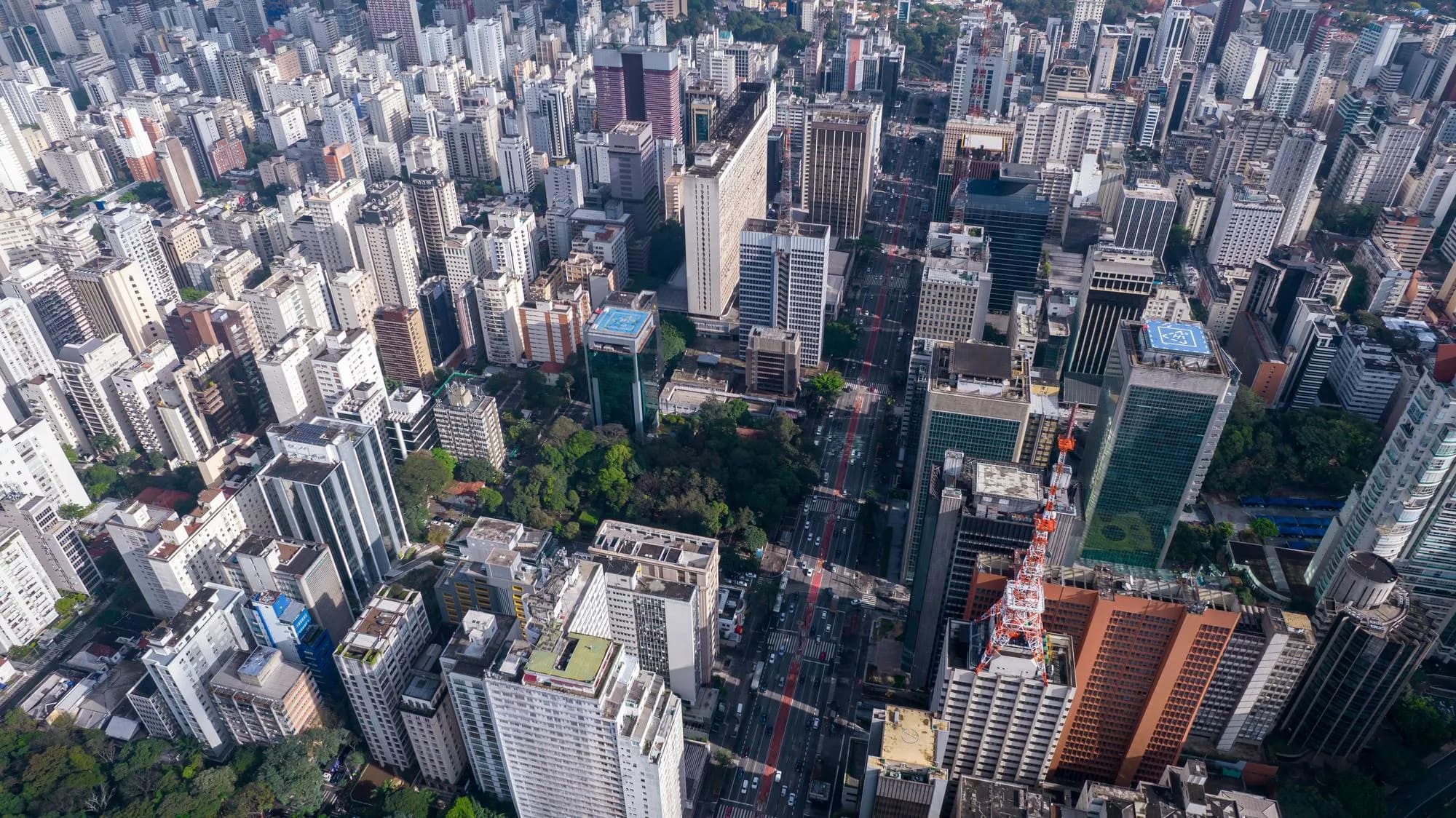 Vista aérea de grandes edifícios e áreas verdes em São Paulo.